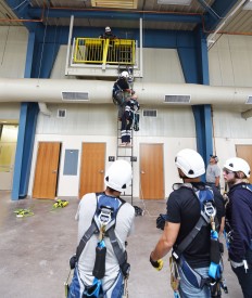 Students in the new hire training class for Granite Services International, participate in a Tower Rescue Training exercise, prior to climbing the wind turbine located adjacent to the North American Wind Research and Training Center.