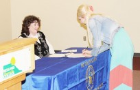 Ashlee Bradley (right), a dual enrolled student from Tucumcari High School, signs her name as a new member of the Phi Theta Kappa (PTK) International Honor Society, during a special ceremony at Mesalands Community College.