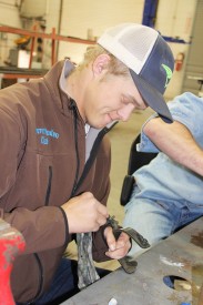 Colton Jackson, a student at Clarendon College pursuing Ranch and Feedlot Operations, shines up a pair of spurs he built during a one-week course at Mesalands Community College. 