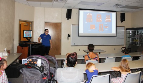 Sanda Garrett explains the different types of life of vests and how they are used to a group of parents and children of the Quay County Home Visiting Program at the Mesalands Community College’s Dinosaur Museum and Natural Sciences Laboratory last week. Following the water safety presentation, the parents and children took a tour of the Mesalands Dinosaur Museum.