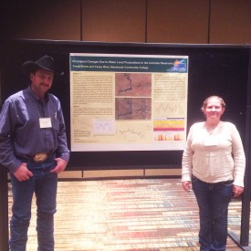 Terrill Stowe, Wind Energy Technology Faculty and researcher, with Casey West, a Wind Energy Technology student at Mesalands, pose for a photo in front of their research poster at the symposium.