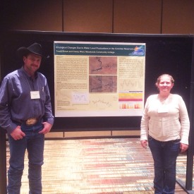 Terrill Stowe, Wind Energy Technology Faculty and researcher, with Casey West, a Wind Energy Technology student at Mesalands, pose for a photo in front of their research poster at the symposium. 